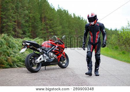 Krasnoyarsk, Russia - May 29, 2018: Beautiful Motorcyclist In Full Gear And Helmet On A Red And Blac
