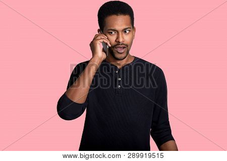 African American Man Has Telephone Coversation, Hears Something Unpleasant News, Looks Aside, Wears 