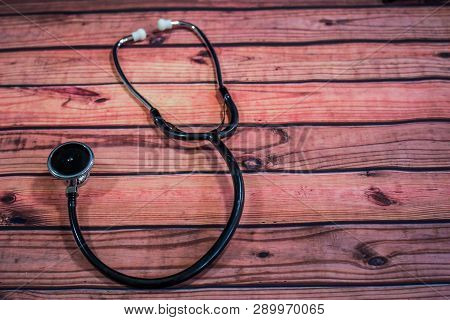 Black Stethoscope And Diaphragm On Wooden Table