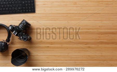 Photographer Bamboo Desk Table With Film Camera, Laptop Computer, Earphones And Supplies. Top View, 