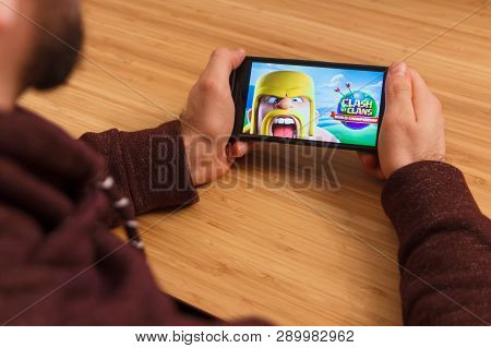 Prague, Czech Republic - March 16, 2019: Man Holding A Smartphone And Playng The Clash Of Clans: Wor