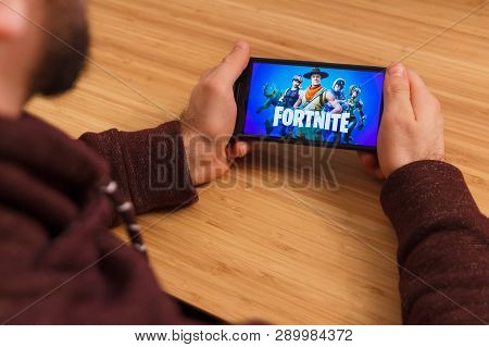 Prague, Czech Republic - March 16, 2019: Man Holding A Smartphone And Playng The Fortnite Mobile Gam