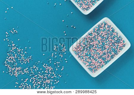 Colorful Nonpareils Cake Candy Sprinkles In Two White Rectangular Bowls And Spoon On Blue Background