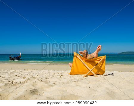 Woman enjoying her holidays on a transat at the tropical beach in Thailand
