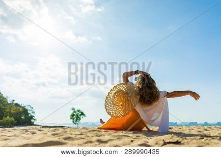Woman enjoying her holidays on a transat at the tropical beach in Thailand