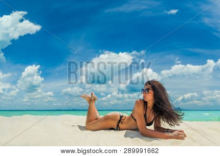 Woman enjoying her holidays on a transat at the tropical beach in Thailand