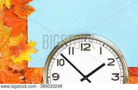 Plain Wall Clock In The Center Of Autumn Orange Red Leaves And Fall Foliage. Two Oclock. Time Manage