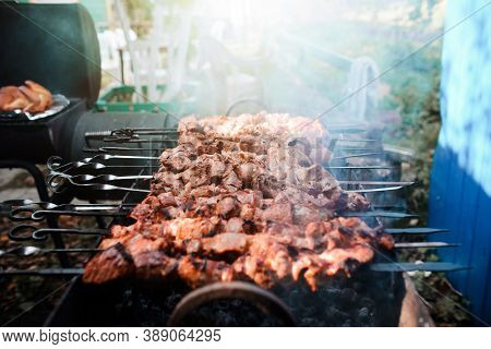 The Meat Is Grilled On Charcoal, Top View. Barbecue Cooking. Smoke Rises Up From Grilled Meat