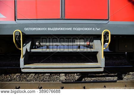 Pull-out Step For Passengers At The Train, Close-up. The Sign On The Train Caution Retractable Step