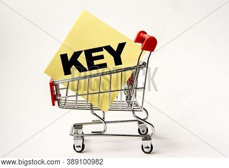 Shopping Cart And Text Key On Yellow Paper Note List. Shopping List, Business Concept On White Backg