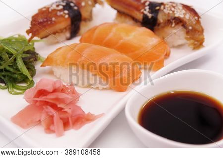 Japanese Sushi Food On A White Plate, Served With Ginger And Seaweed Salad. Salmon Nigiri, Shrimp Ni