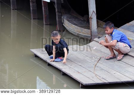 Pathumthani, Thailand July 15, 2017: Two Boy On The Waterfront, Prepare The Bait For Fishing With Ba