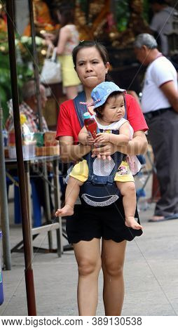 Pathumthani, Thailand - August 6, 2017 : Mother Walking With Her Daughter In The Baby Mop Up Backpac