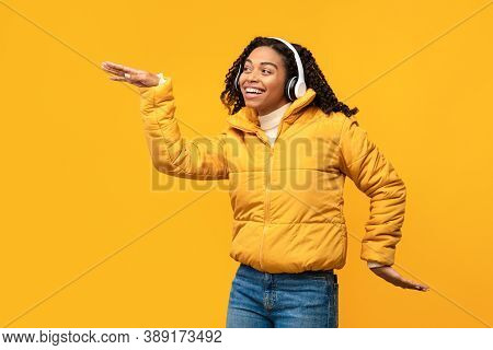Cheerful African American Lady Listening To Music Wearing Wireless Headphones, Dancing Having Fun Po