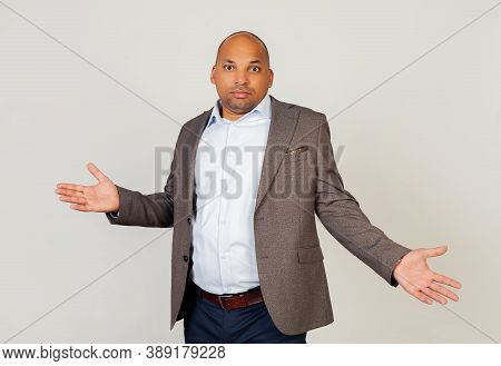 Young Male African American Businessman Looking At The Camera, Spread His Hands Guiltily. An Ignoran