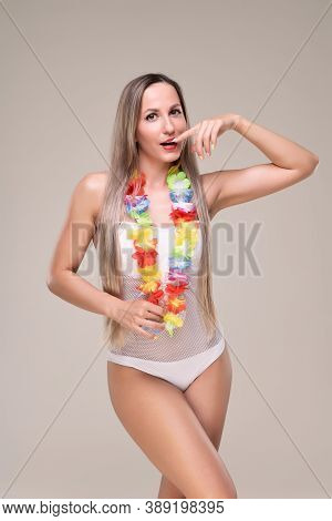 Beautiful Slim And Fit Girl With Long Blond Hair In Whiteswimsuit. Glowing Skin