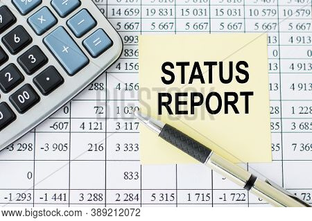 Text Status Report On The Card Lying On The Table Next To The Pen And Calculator.