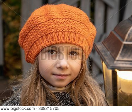 Halloween Autumn Kids. Portrait Magic Girl 6 Years Old In Coat, Hat With Street Lantern In Park. Clo