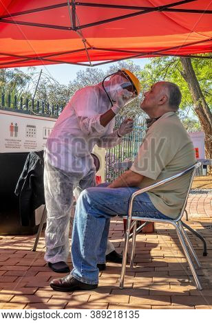 African mobile lab for covid testing in the yard, Caucasian patient getting tested