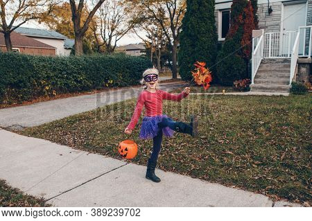 Trick Or Treat. Happy Child Girl With Red Pumpkin Basket Going To Trick Or Treat On Halloween Holida
