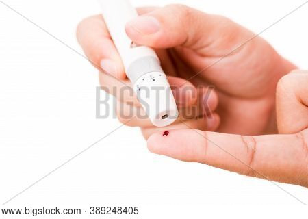Closeup Woman Measuring Glucose Level Using A Hand Test Lancelet On The Finger She Monitors High Blo