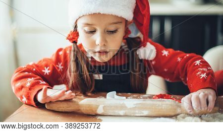 Caucasian Girl Is Rolling The Dough During A Christmas Preparation At Home Wearing Santa Clothes