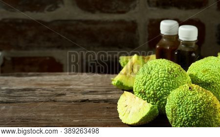 Fruit Of The Maclura Pomifera Tree Or Horse Apple On A Wooden Table. Sliced ​​adam's Apple For Medic