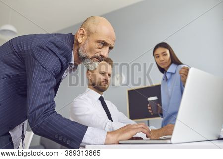 Group Of Business Partners Looking At Laptop Screen For Presentation Of New Project