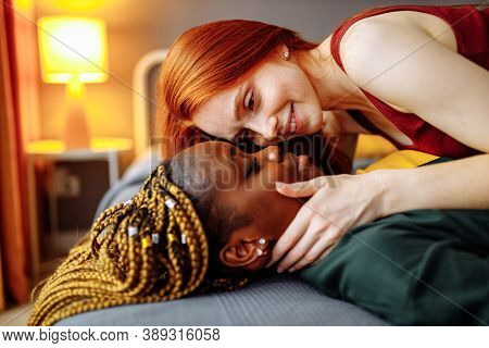 Cheerful Afro And European Lesbian Women At Home On The Bed