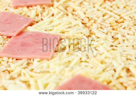 Sarı peynir ve pembe jambon ile lezzetli Pizza yakın.