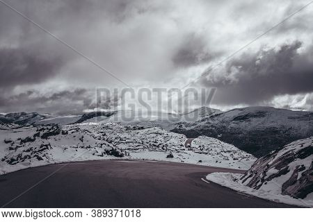 Tight Turn On The Narow Mountain Road With Snow, Mountain Landscape View With Bus In The Far Distanc