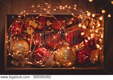 Christmas balls and lights in a box on a wooden table for Christmas celebrations