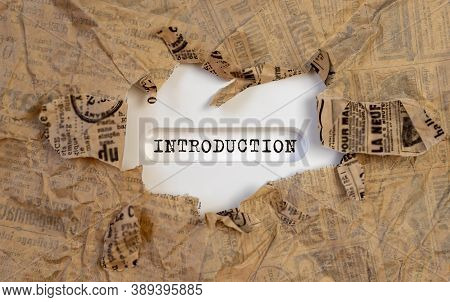 Closeup Of A Handwritten Word Introduction On White Table Through Torn Paper.