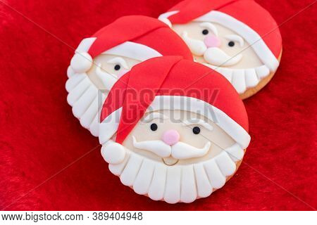 Christmas Cookies With Santa Face On Red Fur Background 
