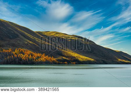 Sunlight And Shade On The Hill Slopes Rolling Down To The Shores Of Lake Tekapo