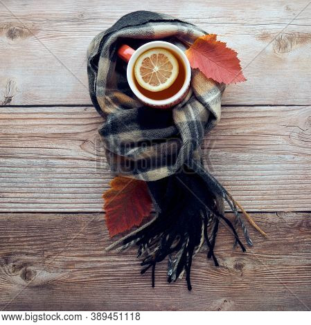 Autumn Leaves, Cup Of Black Tea With Lemon Slice And Warm Scarf On Wooden Table. Fall Season, Leisur