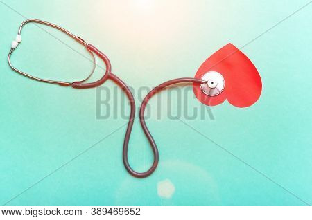 Stethoscope And Red Heart On Green Background. Top View.