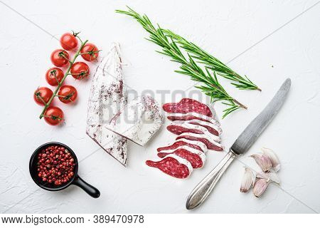 Sliced Cuts Of Longaniza, Dry Cured Spanish  Sausage With Herbs And Spices On White Textured Backgro