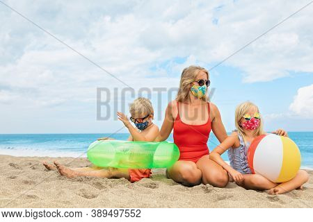 Funny Children In Sunglasses, Inflatable Toys On Tropical Sea Beach. New Rules To Wear Cloth Face Co
