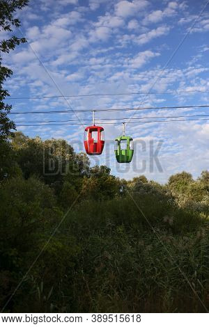 Red And Green Cable Car Cabins Against The Sky