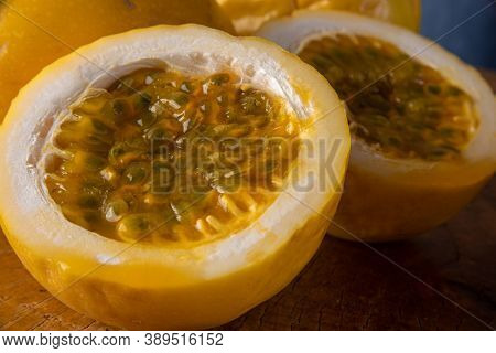 Passion Fruit, Maracujá, In The Foreground On Rustic Wood, Blue Background, Selective Focus.