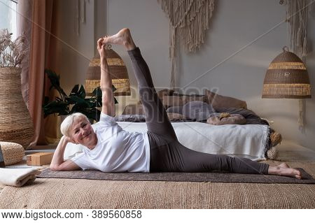 Woman Doing Fitness Workout, Exercise Stretching Legs, Anantasana Or Side Reclining Leg Lift Yoga Po