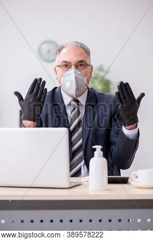 Old male boss employee working during pandemic