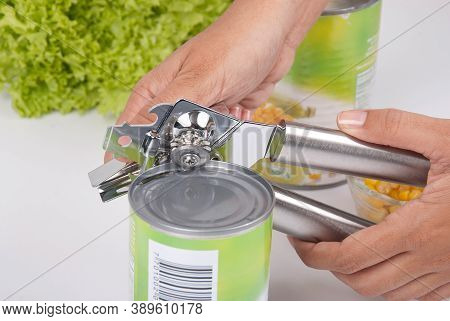 Woman's Hands Using A Can Opener; Photo On White Background.