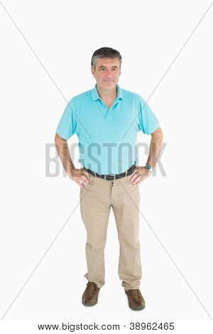 Uomo sorridente con le mani sui fianchi indossando clothers casual