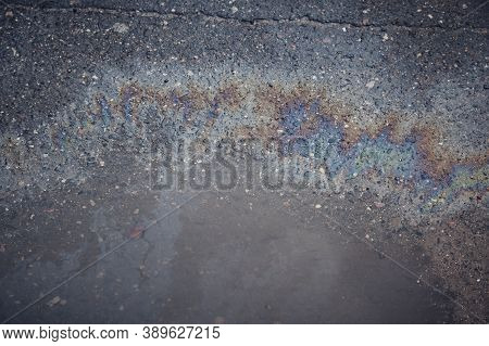 Gas Stain On Wet Asphalt Caused By A Leak Under A Car Or Truck