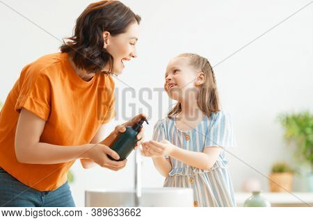 A cute little girl and her mother are washing their hands. Protection against infections and viruses.     