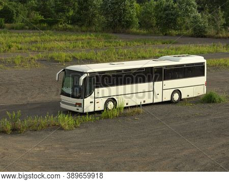 White Bus Stands Alone In The Field Big White Bus In The Parking Lot. One Bus In A Large Parking Lot