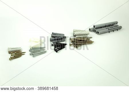 Construction Screws And Dowels On An Isolated White Background. Old Screws And Dowels Are In A Row. 