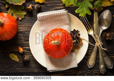 Thanksgiving Food Concept. Autumn Table Setting With Craft Plate, Silverware And Fall Decorations At